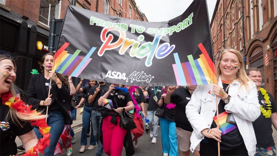 Colleagues marching in Pride parade with banner saying 'proud to support Pride'