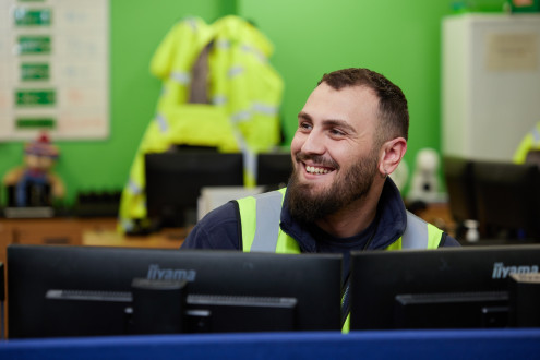 Colleague at ALS smiling over computer monitor