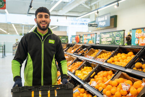 Colleague in store unpacking oranges