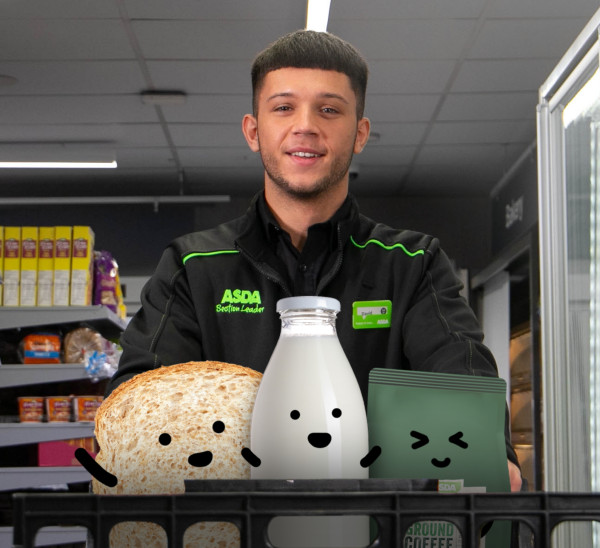 Asda Express colleague pushing a trolley full of grocery characters with drawn-on smiley faces