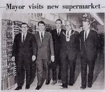 Historical newspaper clipping of mayor and smartly-dressed colleagues with headline 'mayor visits new supermarket'